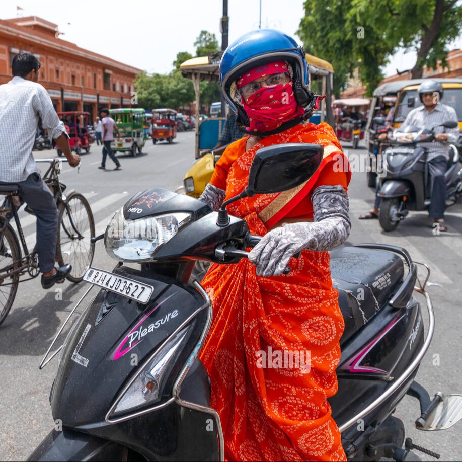 indian-woman-in-sari-riding-on-scooter-in-the-street-rajasthan-jaipur-india-2A3X29R