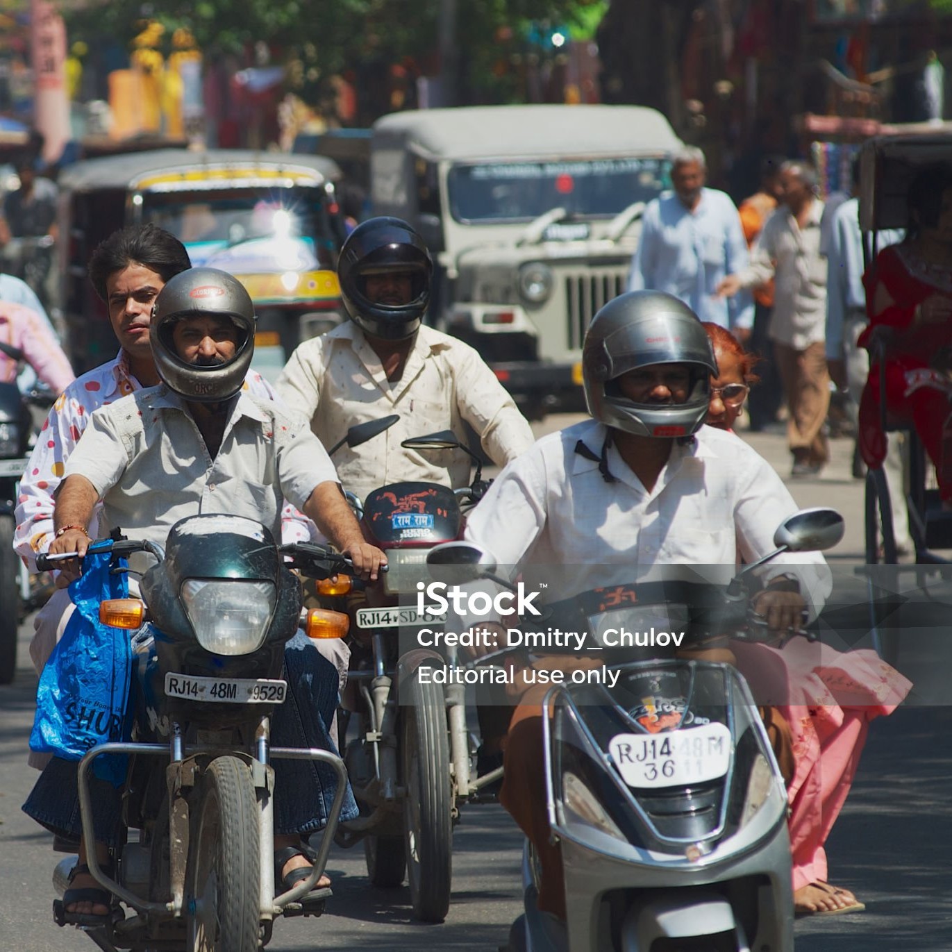 Jaipur, India - March 30, 2007: Unidentified people ride motorbikes by the street during morning rush hour in Jaipur, India.